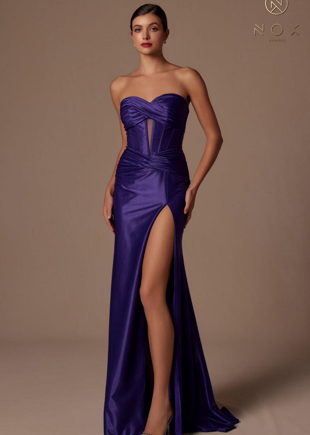A woman wearing a purple strapless dress with a sweetheart neckline and a high slit on the left side. The dress appears to be formal and floor-length.