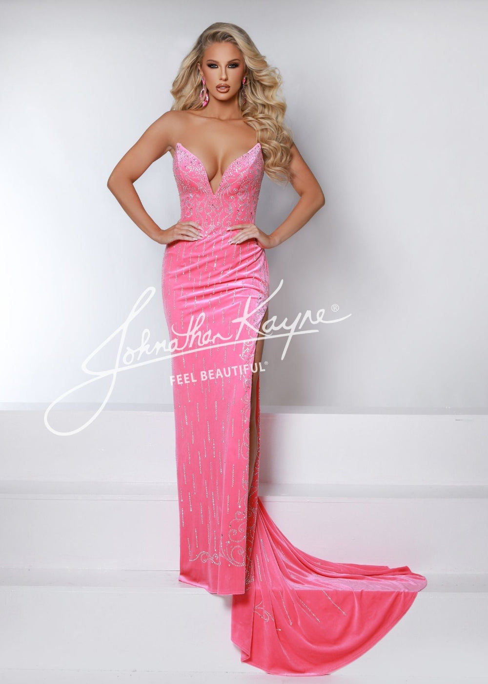 A woman wearing a pink, strapless, maxi dress with a sweetheart neckline and a visible train in the background.