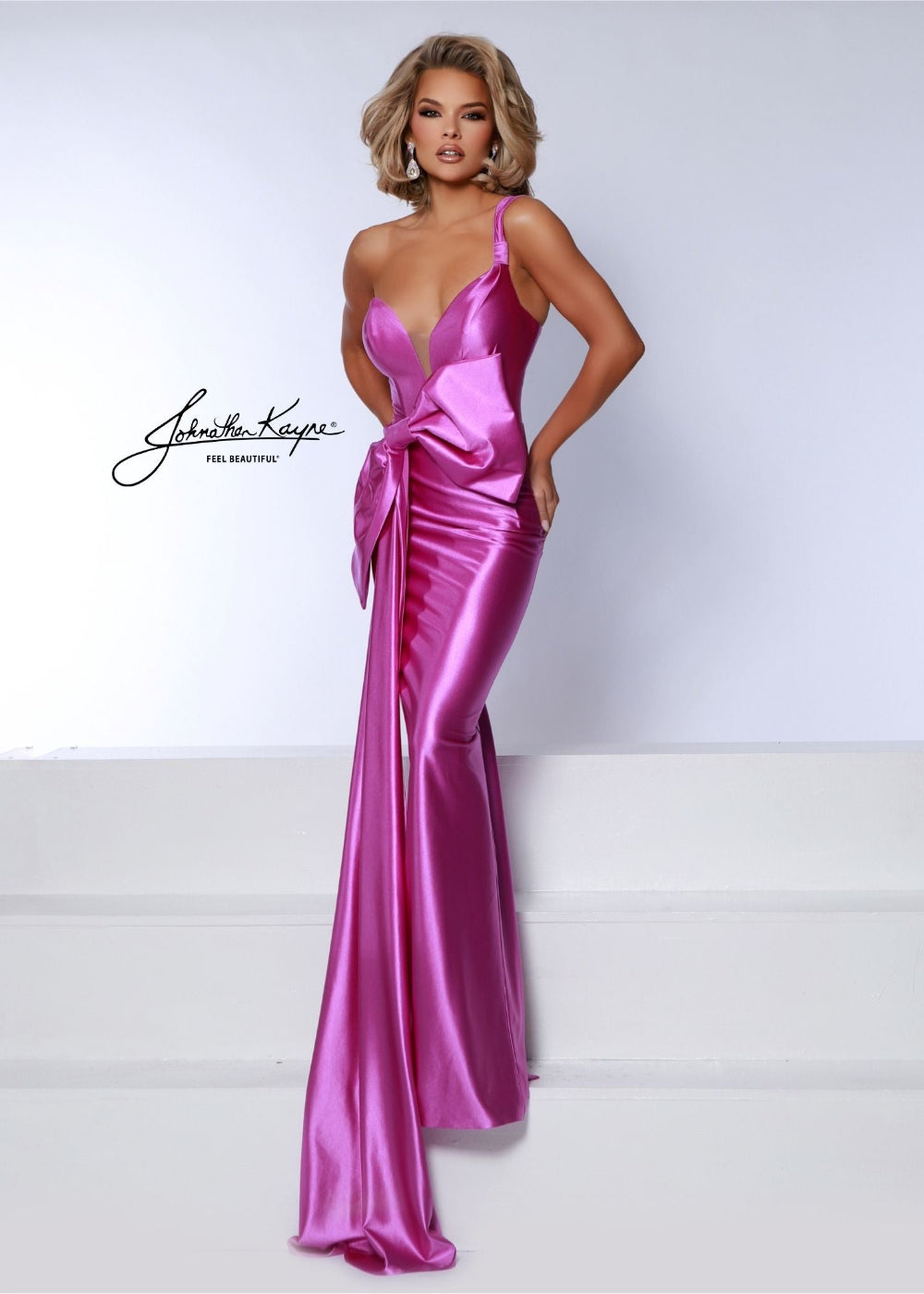 A model wearing a fuchsia sleeveless dress with a deep v-neckline and a bow detail on the waist.