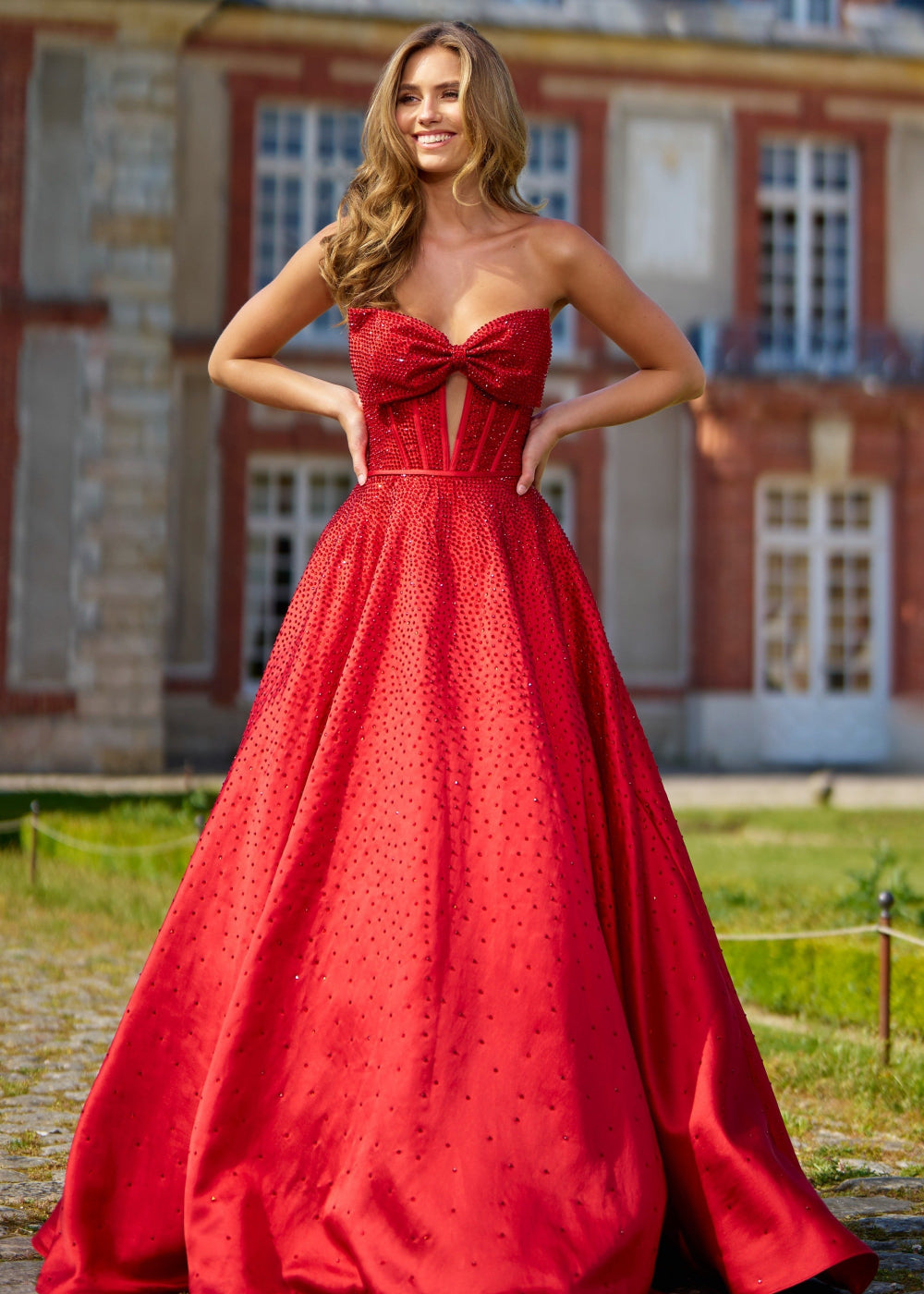 A woman wearing a red Sherri Hill 56900 evening gown with a sweetheart neckline and a full skirt.