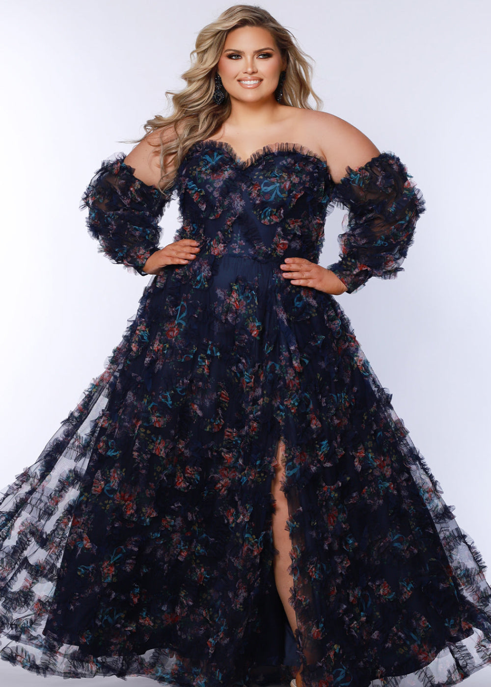 A woman wearing a navy blue, floral, off-the-shoulder, maxi dress with long sleeves and a split skirt.