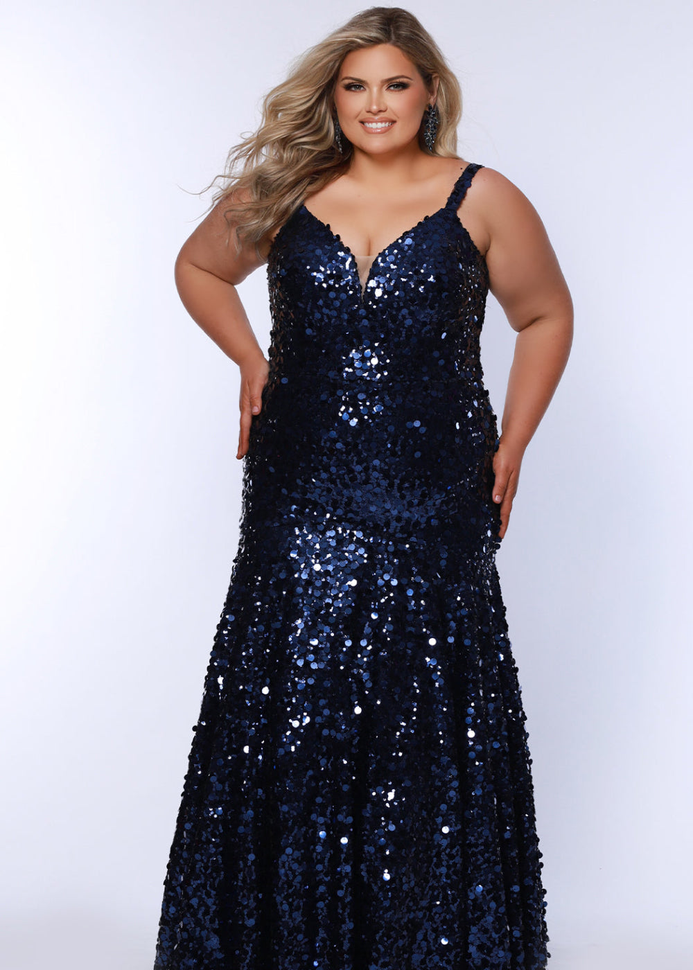 A plus-size model wearing a navy blue, sequin, V-neck, sleeveless, maxi dress by Sydney's Closet.