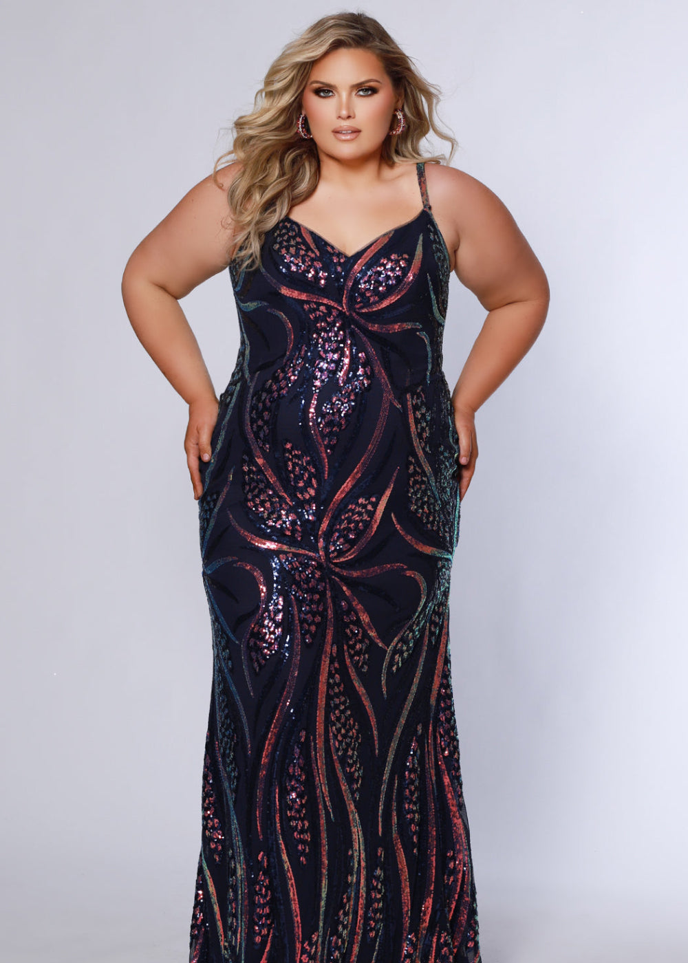 A woman wearing a navy blue, form-fitting dress with sequin embellishments and a V-neckline.